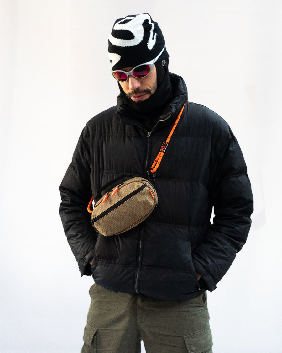 Sling Bag - Medium in Dune, worn across the body with a rope strap.