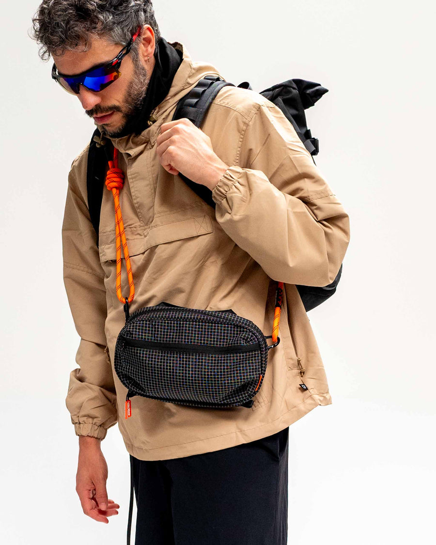 Sling Bag - Large in Black, worn across the body with an orange rope strap.
