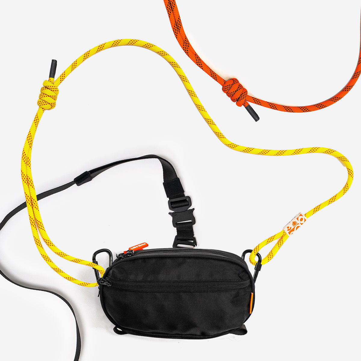 A black sling bag with a yellow climbing-rope strap and carabiners