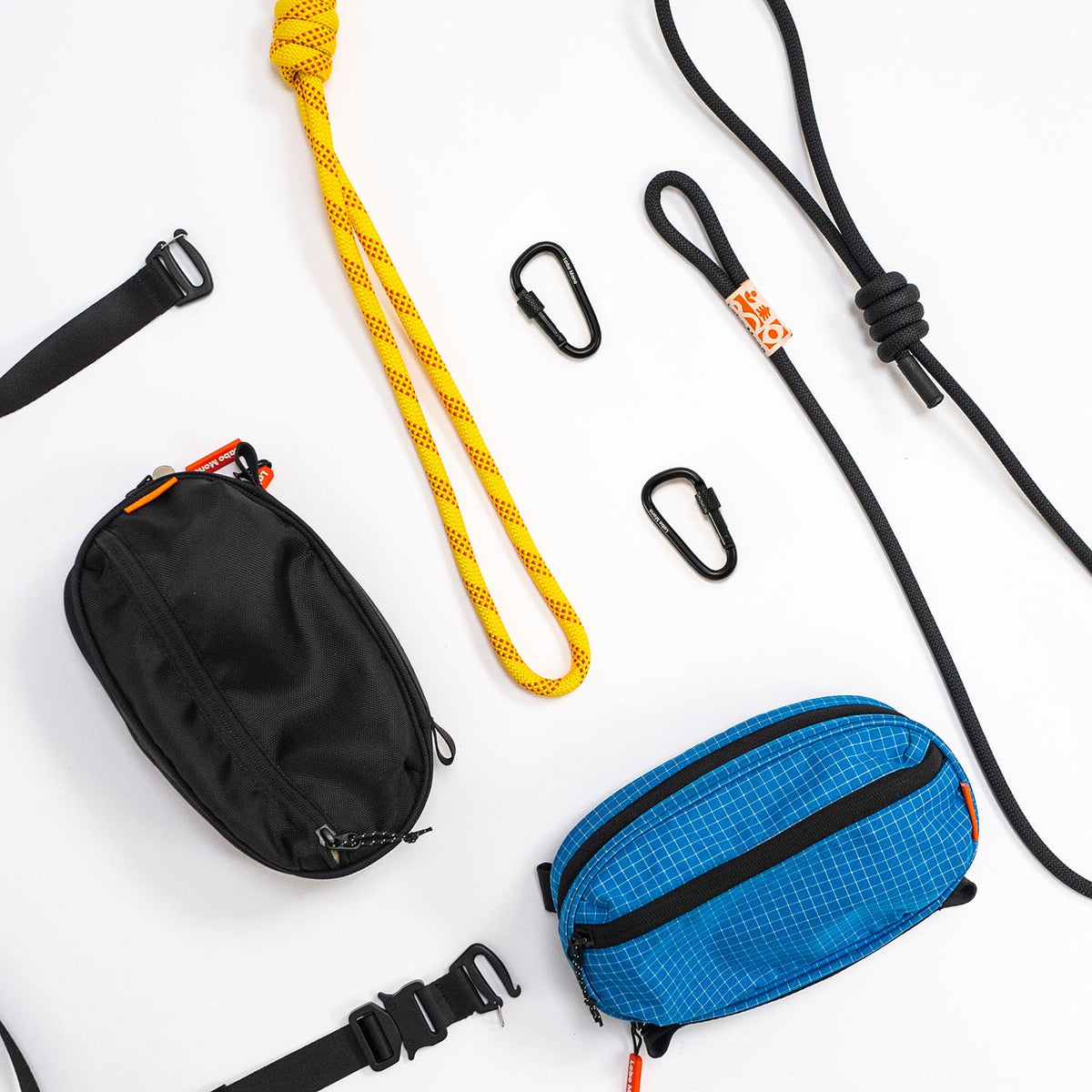 Two sling bags, climbing-rope straps, flat straps and carabiners laid out as separate parts