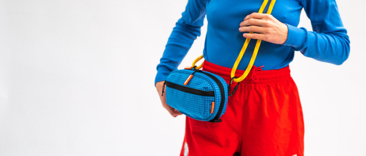 A blue sling bag worn at the waist